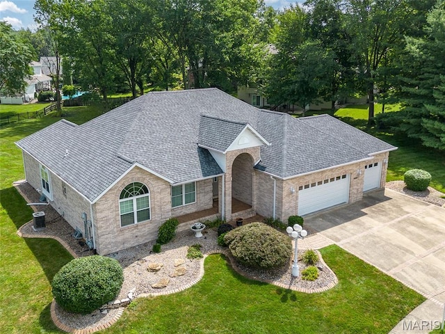 1805 Lincoln Knolls Dr, Edwardsville, IL 62025 - view of front of property with a garage, concrete driveway, a front lawn, a shingled roof, and stone siding