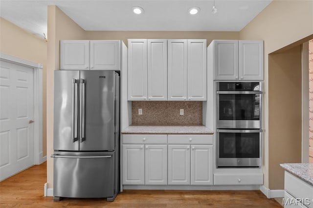 1805 Lincoln Knolls Dr, Edwardsville, IL 62025 - kitchen with stainless steel appliances, light wood finished floors, decorative backsplash, light stone countertops, and recessed lighting
