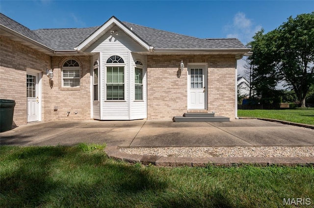 1805 Lincoln Knolls Dr, Edwardsville, IL 62025 - back of house with brick siding, roof with shingles, a patio, entry steps, and a lawn