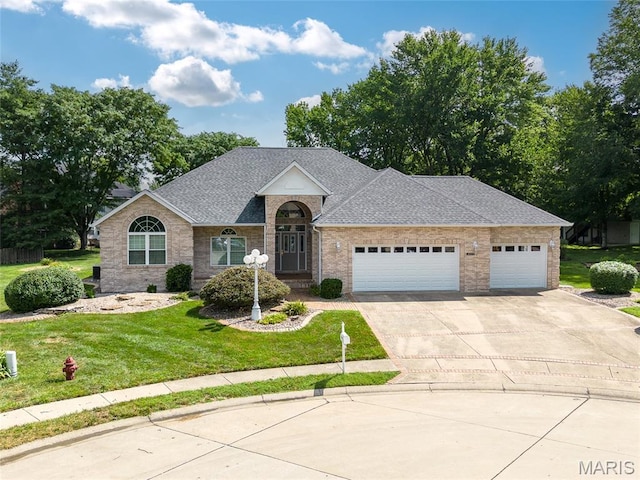 1805 Lincoln Knolls Dr, Edwardsville, IL 62025 - view of front of property with an attached garage, concrete driveway, a shingled roof, a front yard, and brick siding