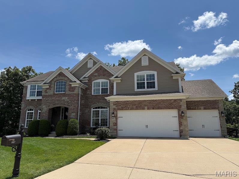 887 Arbor Chase Dr, Wildwood, MO 63021 - traditional-style house with concrete driveway, brick siding, a front lawn, and a garage