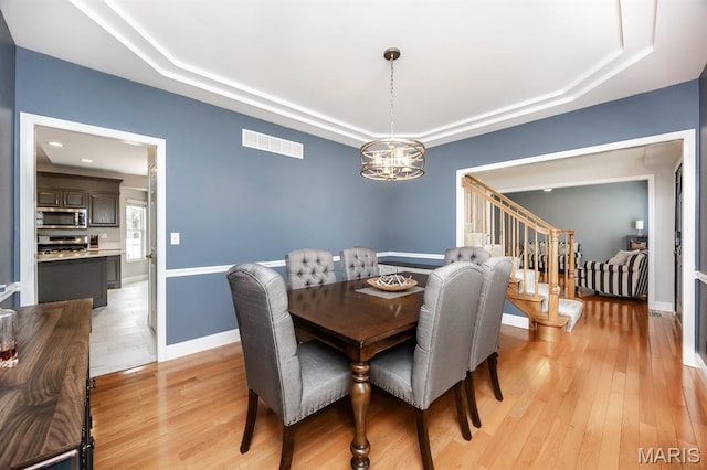 804 Cardiff Ct, Ofallon, IL 62269 - dining space with a raised ceiling, a chandelier, stairway, and light wood-style floors