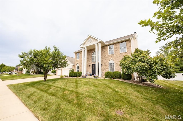804 Cardiff Ct, Ofallon, IL 62269 - neoclassical home with concrete driveway, a front lawn, brick siding, a chimney, and a garage