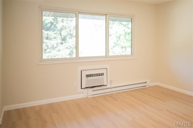 7346 Hazelcrest Dr, Hazelwood, MO 63042 - empty room with a baseboard radiator, an AC wall unit, and wood finished floors