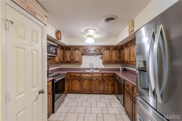 106 Red Bud Cir, Saint Robert, MO 65584 - kitchen with stainless steel appliances, brown cabinetry, a textured ceiling, and light tile patterned flooring
