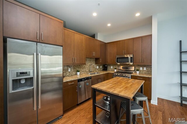 9 N Euclid Ave Unit 509, Saint Louis, MO 63108 - kitchen with stainless steel appliances, light wood-style flooring, backsplash, light stone countertops, and recessed lighting