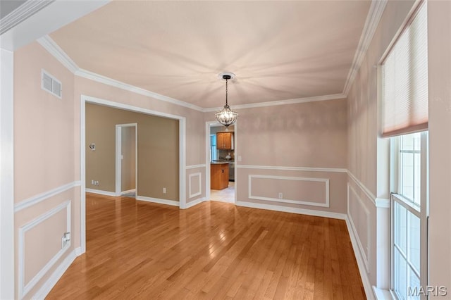 2028 During Dr, Arnold, MO 63010 - unfurnished dining area with a chandelier, light wood-style flooring, crown molding, and a decorative wall