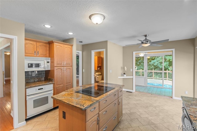 2028 During Dr, Arnold, MO 63010 - kitchen featuring white appliances, dark stone counters, a kitchen island, ceiling fan, and tasteful backsplash