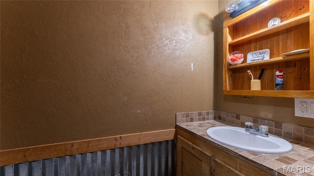 19954 Ironwood Ln, Lebanon, MO 65536 - bathroom featuring tasteful backsplash, vanity, and a textured wall