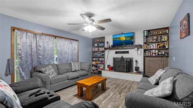 19954 Ironwood Ln, Lebanon, MO 65536 - living room with wood finished floors, ceiling fan, a fireplace, plenty of natural light, and a textured ceiling