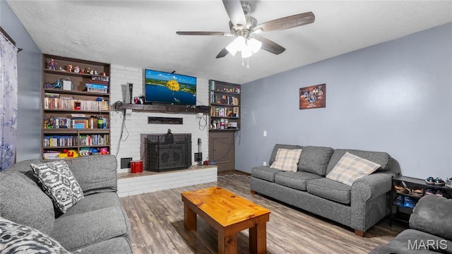 19954 Ironwood Ln, Lebanon, MO 65536 - living room featuring a ceiling fan, wood finished floors, and a brick fireplace