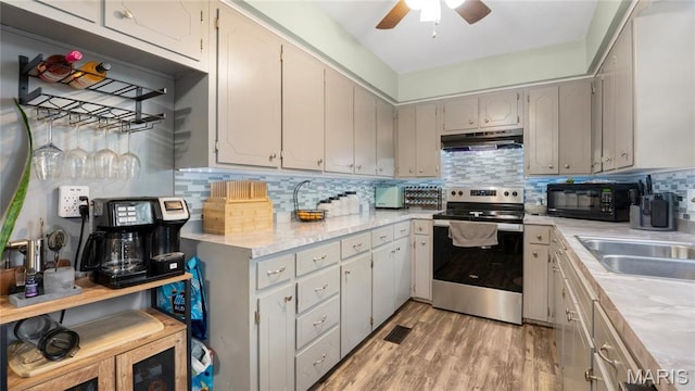 19954 Ironwood Ln, Lebanon, MO 65536 - kitchen with stainless steel electric stove, black microwave, under cabinet range hood, light countertops, and decorative backsplash