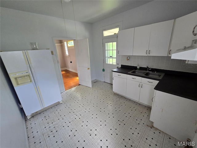 8108 Saint Charles Rock Rd, Saint Louis, MO 63114 - kitchen featuring white fridge with ice dispenser, dark countertops, white cabinetry, and tasteful backsplash