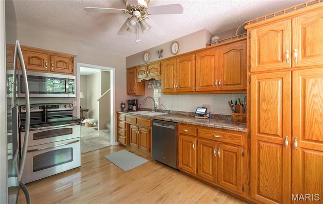 15550 US Highway 63, Rolla, MO 65401 - kitchen with appliances with stainless steel finishes, ceiling fan, light wood-style floors, a textured ceiling, and decorative backsplash