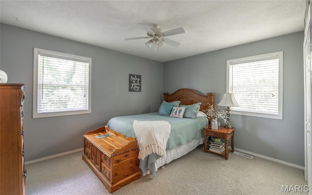 15550 US Highway 63, Rolla, MO 65401 - bedroom with multiple windows, light carpet, ceiling fan, and a textured ceiling