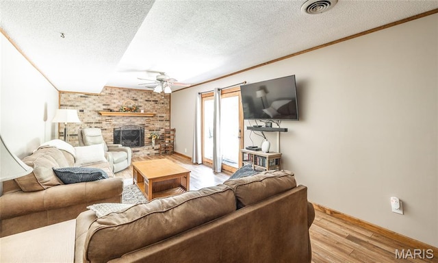 15550 US Highway 63, Rolla, MO 65401 - living area featuring ceiling fan, crown molding, light wood finished floors, a textured ceiling, and a brick fireplace