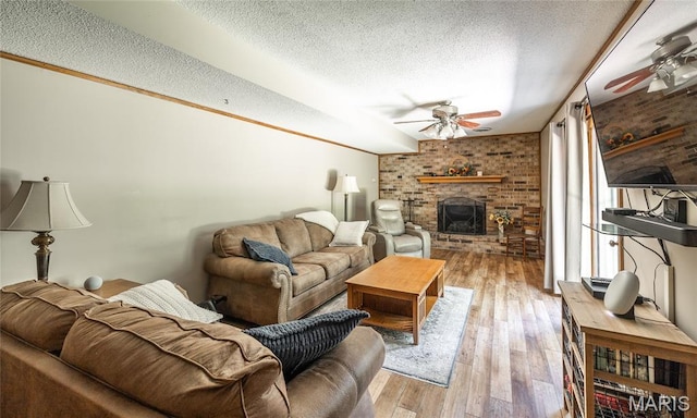15550 US Highway 63, Rolla, MO 65401 - living area with ceiling fan, a textured ceiling, brick wall, a fireplace, and wood finished floors