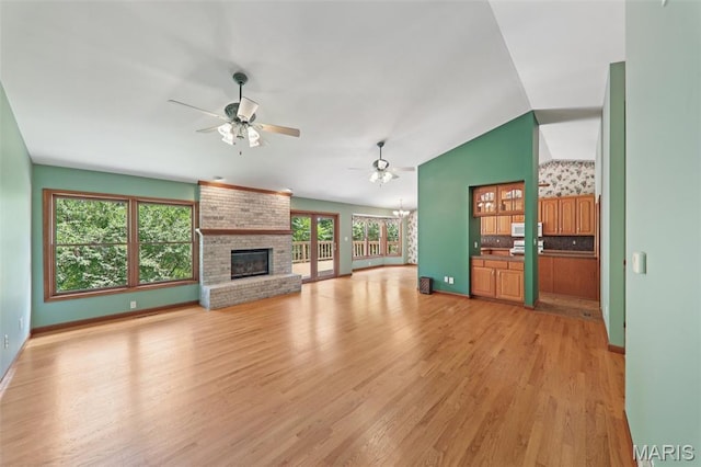 67 High Trails Dr, Eureka, MO 63025 - unfurnished living room with a ceiling fan, a fireplace, light wood-type flooring, vaulted ceiling, and a chandelier