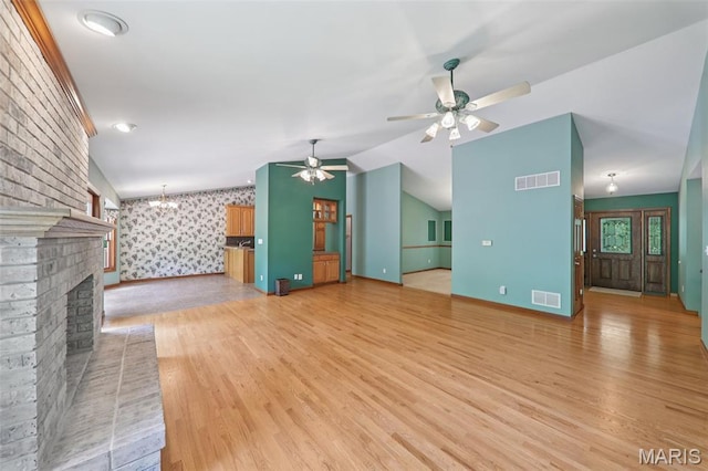 67 High Trails Dr, Eureka, MO 63025 - unfurnished living room featuring wallpapered walls, a brick fireplace, a ceiling fan, light wood-type flooring, and vaulted ceiling