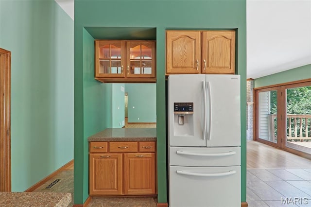 67 High Trails Dr, Eureka, MO 63025 - kitchen with white refrigerator with ice dispenser, glass insert cabinets, and light tile patterned flooring
