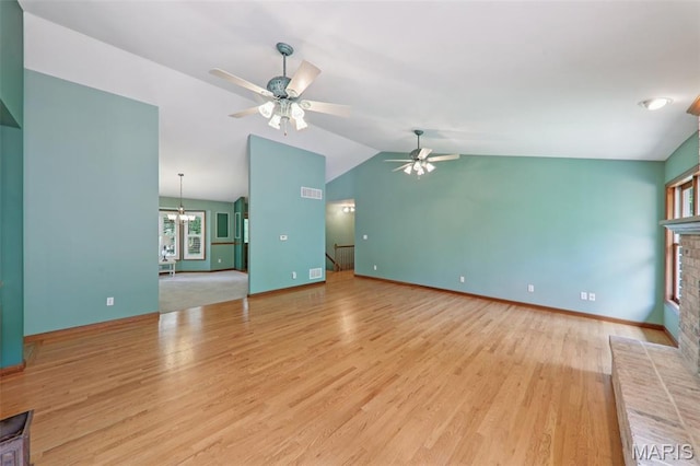 67 High Trails Dr, Eureka, MO 63025 - unfurnished living room with lofted ceiling, a ceiling fan, a fireplace, light wood-style flooring, and a chandelier