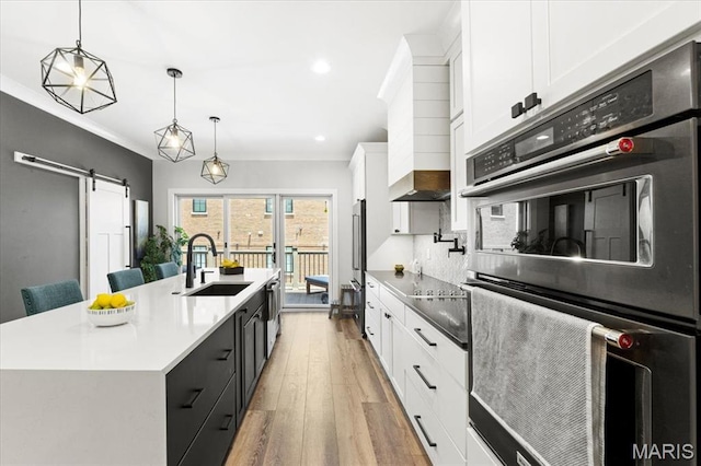 9 E Main St, Washington, MO 63090 - kitchen featuring stainless steel double oven, a barn door, white cabinets, a spacious island, and light wood-type flooring