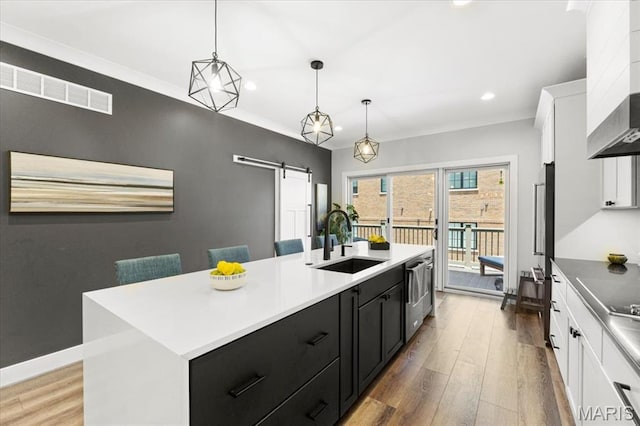 9 E Main St, Washington, MO 63090 - kitchen with a barn door, dark cabinets, wood finished floors, a kitchen island with sink, and recessed lighting