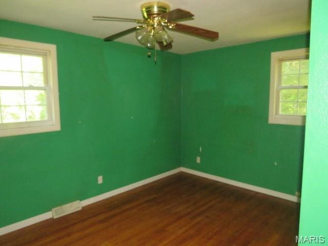 5129 Rapp Rd, Granite City, IL 62040 - unfurnished room with healthy amount of natural light, dark wood-type flooring, and a ceiling fan