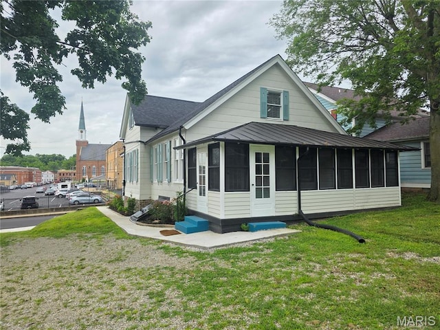 371 Jefferson St, Saint Genevieve, MO 63670 - rear view of property featuring a sunroom, a lawn, roof with shingles, and a standing seam roof