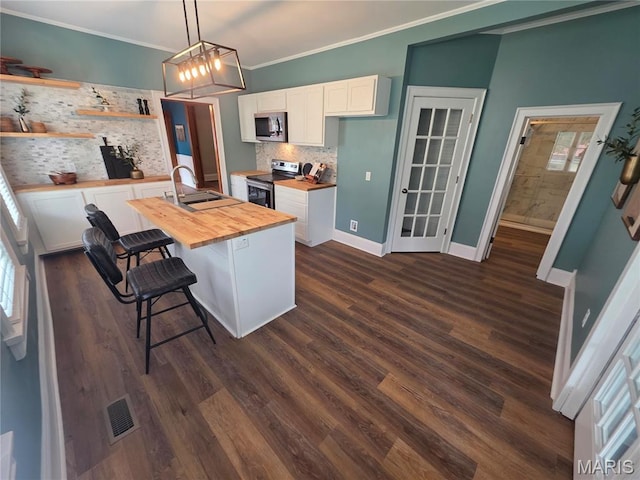 371 Jefferson St, Saint Genevieve, MO 63670 - kitchen with wood counters, stainless steel appliances, white cabinets, decorative backsplash, and a kitchen breakfast bar