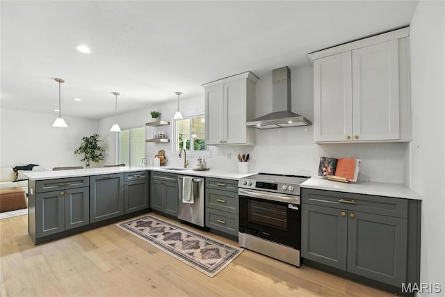 15282 Springrun Dr, Chesterfield, MO 63017 - kitchen with wall chimney range hood, appliances with stainless steel finishes, light wood finished floors, light countertops, and recessed lighting
