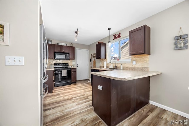 182 Cherrywood Parc Dr, Ofallon, MO 63368 - kitchen with black appliances, light wood-type flooring, a peninsula, tasteful backsplash, and light countertops