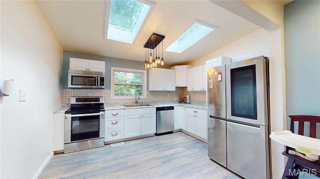 224 Lucinda Dr, Fairview Heights, IL 62208 - kitchen with appliances with stainless steel finishes, a skylight, backsplash, white cabinetry, and lofted ceiling