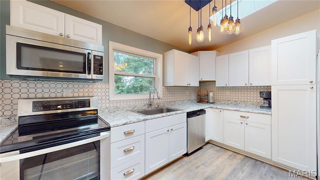 224 Lucinda Dr, Fairview Heights, IL 62208 - kitchen with appliances with stainless steel finishes, white cabinets, decorative backsplash, light wood-style flooring, and light stone counters