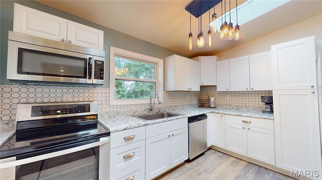 224 Lucinda Dr, Fairview Heights, IL 62208 - kitchen featuring stainless steel appliances, white cabinetry, backsplash, light wood-style floors, and light stone countertops