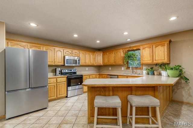 1124 Carpentry Cir, Lebanon, MO 65536 - kitchen with appliances with stainless steel finishes, recessed lighting, light countertops, a peninsula, and light tile patterned floors