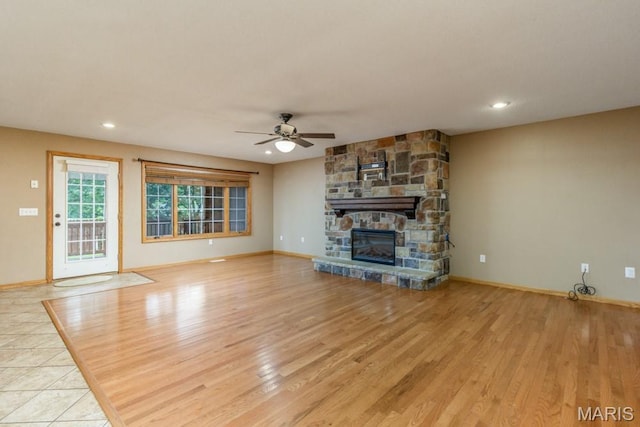 1124 Carpentry Cir, Lebanon, MO 65536 - unfurnished living room featuring a ceiling fan, a stone fireplace, wood finished floors, and recessed lighting