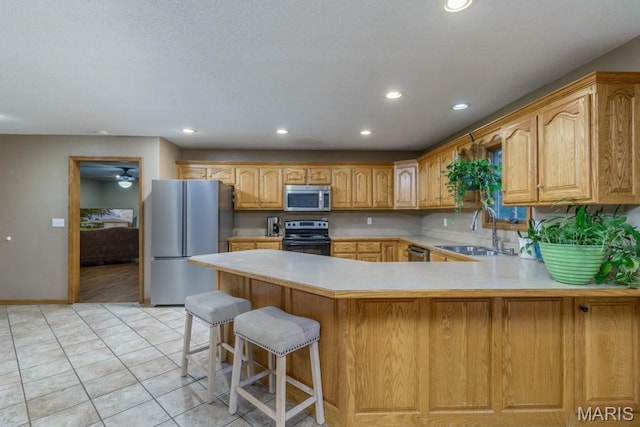 1124 Carpentry Cir, Lebanon, MO 65536 - kitchen featuring appliances with stainless steel finishes, recessed lighting, light countertops, a peninsula, and light tile patterned flooring