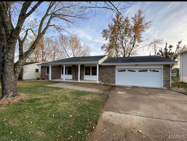 1322 Highland Dr, Rolla, MO 65401 - ranch-style house featuring brick siding, covered porch, driveway, an attached garage, and a front lawn