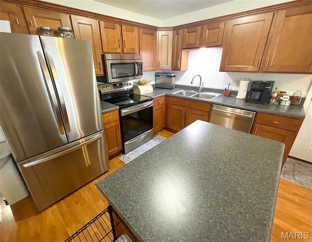 712 W Oak St, Dexter, MO 63841 - kitchen featuring stainless steel appliances, dark countertops, light wood-type flooring, brown cabinets, and a center island