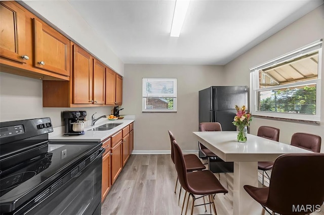 1237 Fairview Ave, University City, MO 63130 - kitchen featuring black appliances, healthy amount of natural light, light countertops, and brown cabinetry