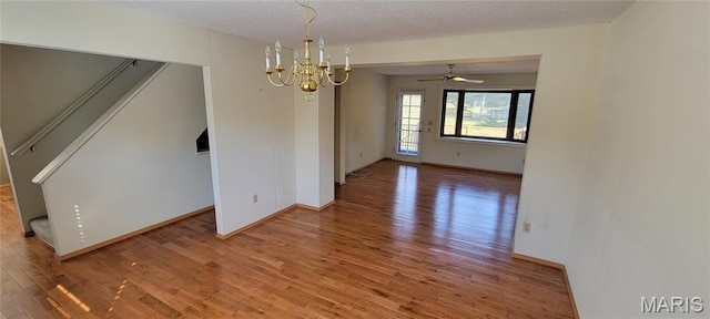 964 Claygate Ct, Ballwin, MO 63021 - unfurnished dining area with light wood-style floors, a chandelier, a textured ceiling, ceiling fan, and stairs