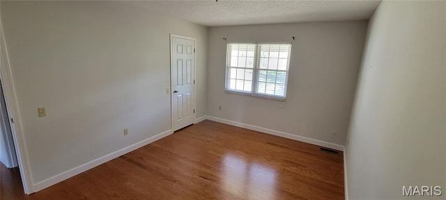964 Claygate Ct, Ballwin, MO 63021 - spare room featuring wood finished floors and a textured ceiling