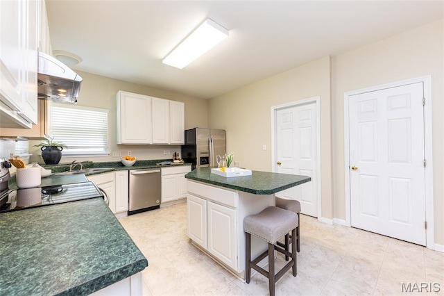 602 Whispering Willows Ct, Ballwin, MO 63021 - kitchen featuring stainless steel appliances, dark countertops, white cabinets, and a breakfast bar area