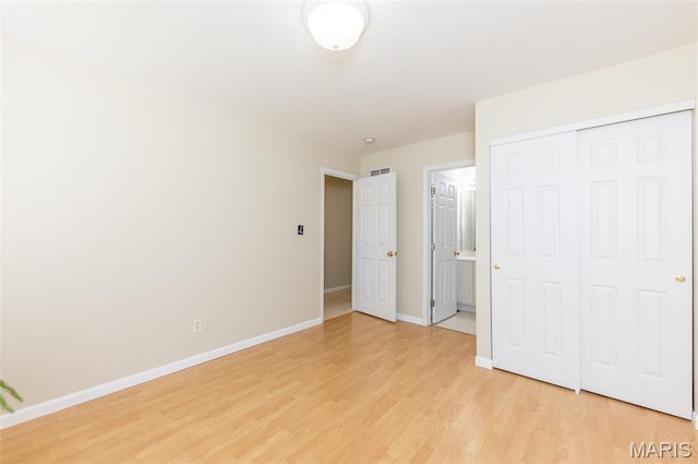 602 Whispering Willows Ct, Ballwin, MO 63021 - unfurnished bedroom with light wood-style flooring, a closet, and connected bathroom