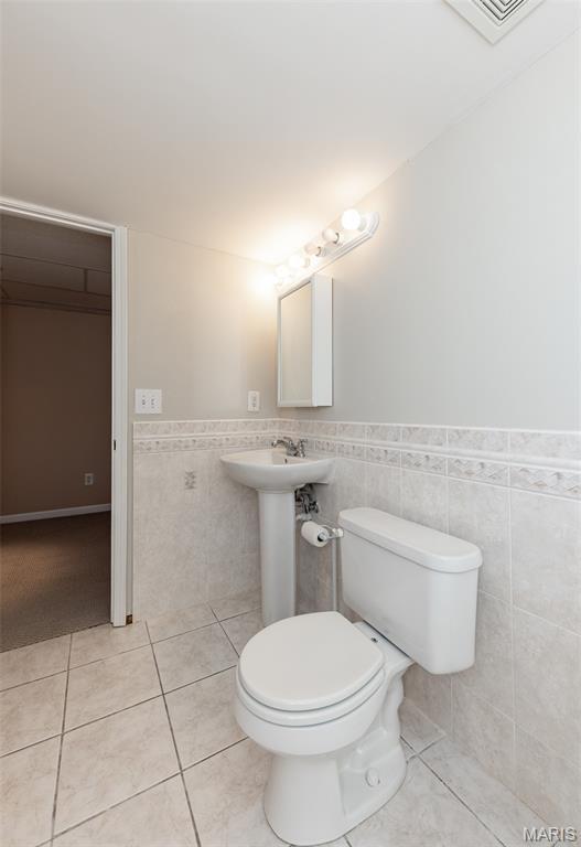 602 Whispering Willows Ct, Ballwin, MO 63021 - bathroom featuring tile walls, wainscoting, and tile patterned flooring