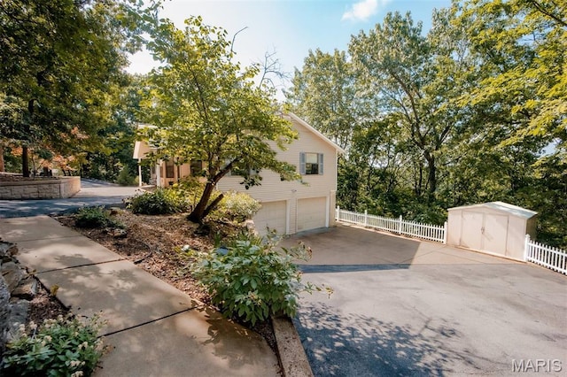 7040 Oak Shadow Ln, High Ridge, MO 63049 - view of side of home featuring an attached garage, driveway, and a shed
