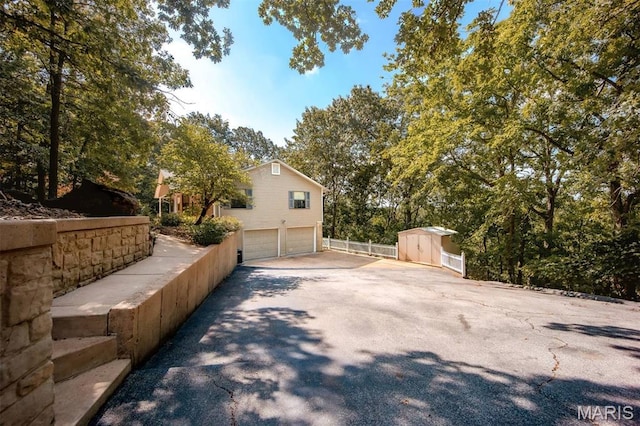 7040 Oak Shadow Ln, High Ridge, MO 63049 - view of property exterior featuring an attached garage, a storage shed, and concrete driveway