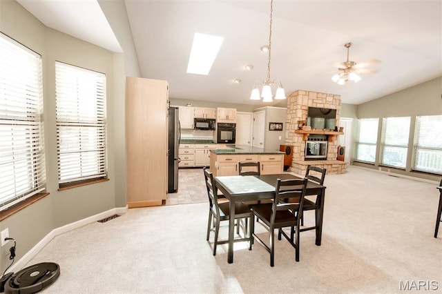 7040 Oak Shadow Ln, High Ridge, MO 63049 - dining area with vaulted ceiling, light carpet, a chandelier, a ceiling fan, and a skylight