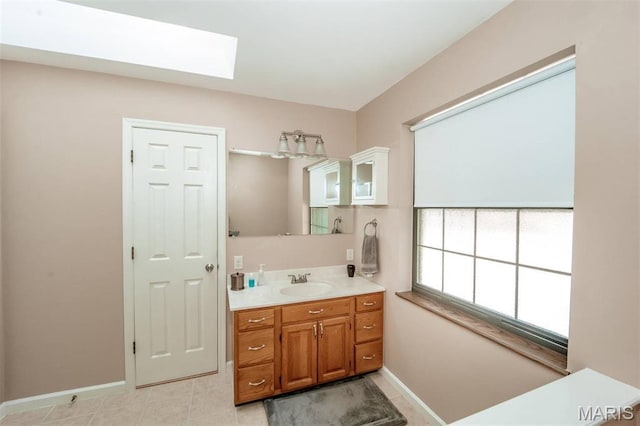 7040 Oak Shadow Ln, High Ridge, MO 63049 - bathroom featuring a skylight, vanity, and tile patterned flooring